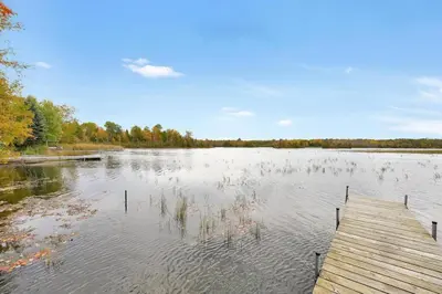 a large lake with a wooden dock in the water at Rustic cottage on Canal Lake in Carden