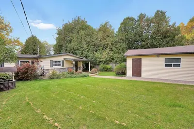 a home with a yard with a house at Rustic cottage on Canal Lake in Carden