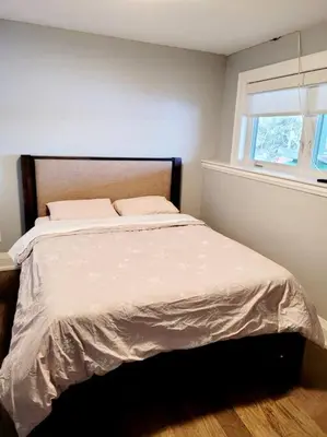 a bedroom with a large bed with a window at Chemong Lake Waterfront Cottage☆privateboatlaunch in Lakefield