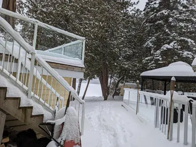 a snow covered stairway to a house with a snowboard at Cozy Escape, Kawarthas Cottage With Sauna in Buckhorn