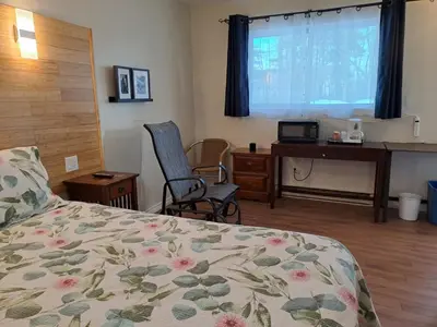 a bedroom with a bed and a desk with a computer at Three Island Motel in Bobcaygeon