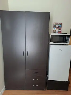 a gray cabinet with a microwave and a refrigerator at Three Island Motel in Bobcaygeon