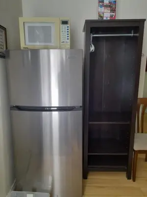 a stainless steel refrigerator in a kitchen with a microwave at Three Island Motel in Bobcaygeon
