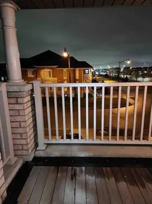a porch with a white fence and a street at night at Luxury 4-Bedrooms Home… in Brampton