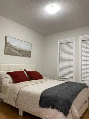 a bedroom with a bed and two windows at Luxury 4-Bedrooms Home… in Brampton