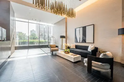 a living room with a black couch and a chair at Traveller home in centre Toronto in Toronto