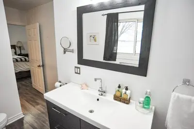 a bathroom with a white sink and a mirror at Modern Rustic Home with Wood Stove & Pool Table in Kemble