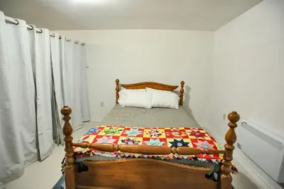 a bedroom with a bed with a quilt on it at Modern Rustic Home with Wood Stove & Pool Table in Kemble