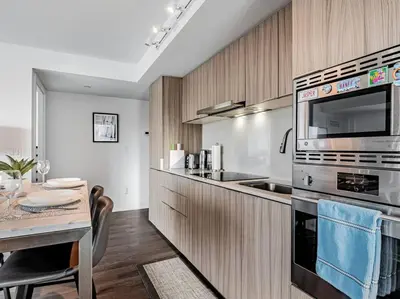 a kitchen with a table and a stove top oven at Luxury Condo on Bay Street in Toronto