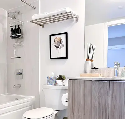 a white bathroom with a toilet and a sink at Luxury Condo on Bay Street in Toronto