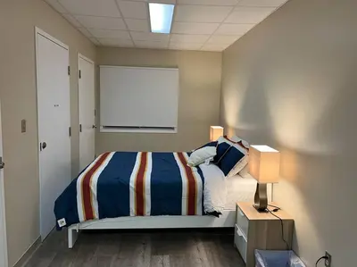 a bedroom with a bed and a window and two lamps at 5 Bedroom Vacation Cottage - King City in Schomberg