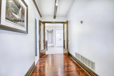 a hallway with white walls and a wooden floor and a painting at 5 Bedroom Vacation Cottage - King City in Schomberg
