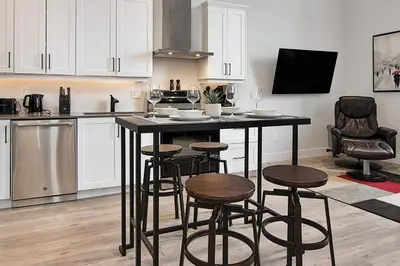 a kitchen with a black island with stools in a room at The National on Queen in Saint Marys
