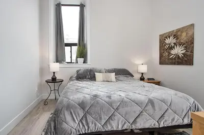 a bedroom with a bed and two lamps and a window at The National on Queen in Saint Marys