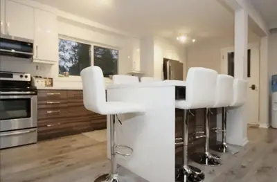 a kitchen with white chairs and a white counter top at La Datcha 20 Acres Private Spa, with Pool, Jacuzzi & Wood Burning Sauna in Cookstown