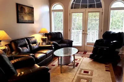 a living room with leather furniture and a table at Modern & Spacious 2 Bedrooms+2 Bathrooms Bungalow in Oakville in Oakville