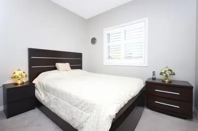 a bedroom with a large bed and two night stands at Modern & Spacious 2 Bedrooms+2 Bathrooms Bungalow in Oakville in Oakville