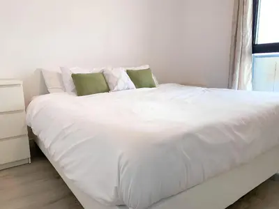 a large white bed in a room with a window at Cozy 1BR Condo w/ Insuite LDRY, Gym & Free Parking in Waterloo