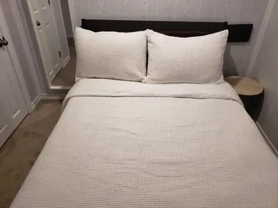 a bed with white sheets and pillows in a room at 2plex, Choose, 1of 2 entire units apparts in Hamilton