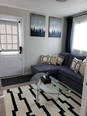 a living room with a blue couch and a glass table at 2plex, Choose, 1of 2 entire units apparts in Hamilton
