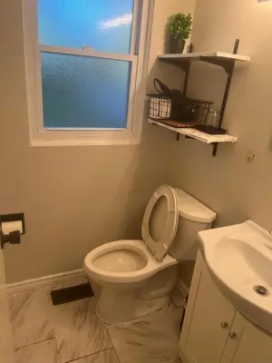 a bathroom with a toilet and a sink and a window at 2plex, Choose, 1of 2 entire units apparts in Hamilton