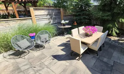 a patio with a table and chairs and flowers at Executive House easy access to Kitchener-Waterloo, Cambridge, Toronto, walk to restaurants in Kitchener