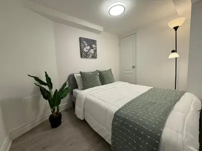 a bedroom with a bed and a potted plant at Modern 2BR in the Heart of Little Italy in Toronto