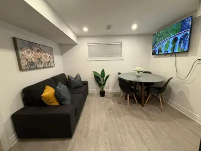 a living room with a couch and a table at Modern 2BR in the Heart of Little Italy in Toronto