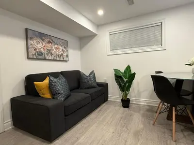 a living room with a couch and a table at Modern 2BR in the Heart of Little Italy in Toronto