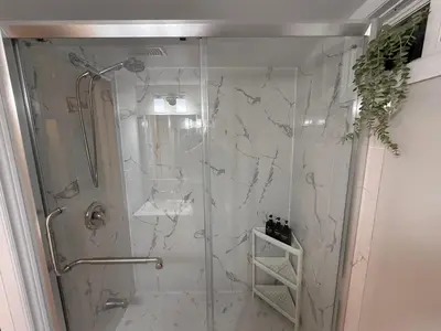 a bathroom with a shower with a glass door at Modern 2BR in the Heart of Little Italy in Toronto