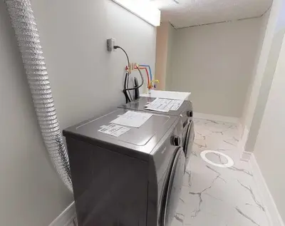 a washer and dryer sitting in a room at Modern 2BR in the Heart of Little Italy in Toronto