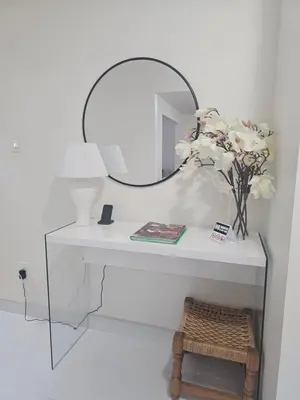 a white table with a mirror and a vase of flowers at 3-Bed 3-Bath Cozy Vacation House in Ajax, Greater Toronto Area, ON, Canada in Ajax