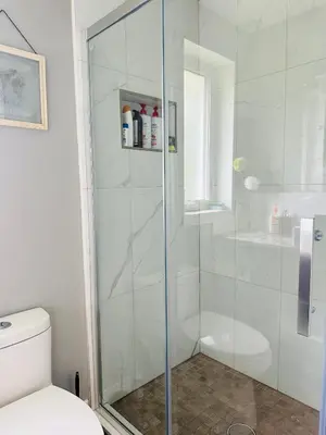 a shower with a glass door in a bathroom at Cozy 3-bedroom farmhouse in wine-country in Niagara on the Lake