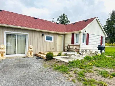 a small house with a porch and a patio at Cozy 3-bedroom farmhouse in wine-country in Niagara on the Lake