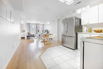 a kitchen with a stainless steel refrigerator and a table at Comfortable Apartment in Richmond Hill in Richmond Hill