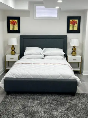 a bedroom with a large bed with two night stands at New Luxurious Studio Apartment in Brampton