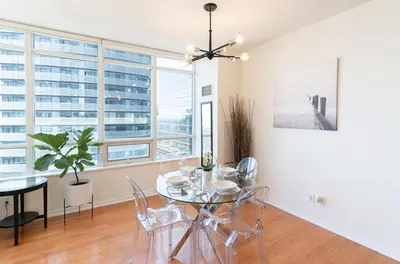 a dining room with a table and chairs and windows at Beautiful Modern Toronto Luxurious Scotiabank Arena in Toronto