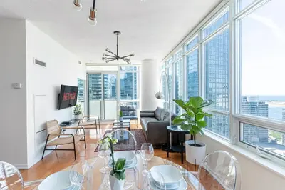 a living room with a table and chairs and large windows at Beautiful Modern Toronto Luxurious Scotiabank Arena in Toronto