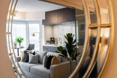 a living room with a couch in front of a mirror at Yorkville Living 1 BR-1BA with Gym in Upscale Area in Toronto