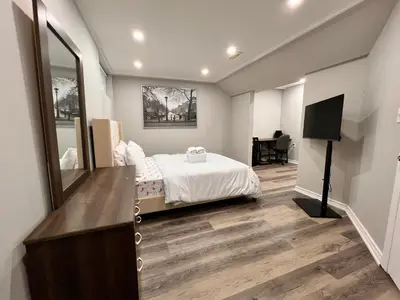 a bedroom with a bed and a mirror and a television at The Hestia Kitchener in Kitchener