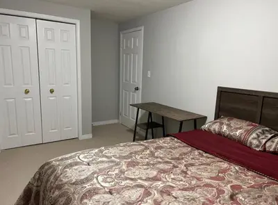 a bedroom with a bed and a table in it at The Hestia Kitchener in Kitchener