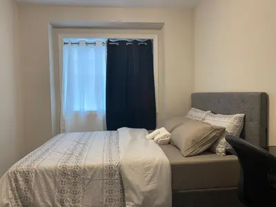 a bedroom with a bed with a blue curtain at Poise Homes Guest Home Cambridge in Cambridge
