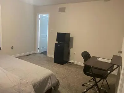 a bedroom with a bed and a desk and a television at Poise Homes Guest Home Cambridge in Cambridge