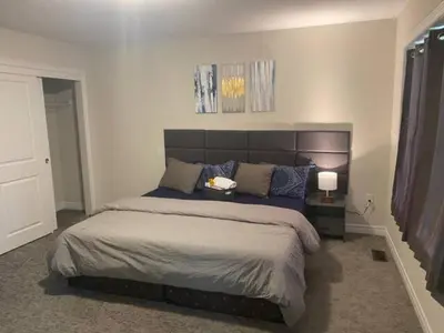 a bedroom with a large bed with blue pillows at Poise Homes Guest Home Cambridge in Cambridge