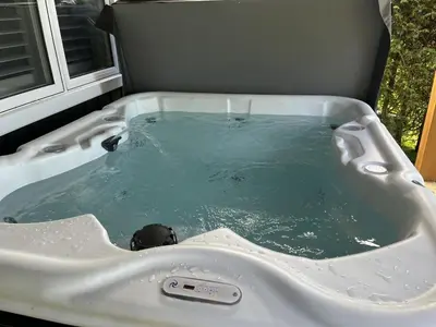 a bath tub filled with water next to a window at Impressive Modern Waterfront Home on Georgian Bay in Port McNicoll