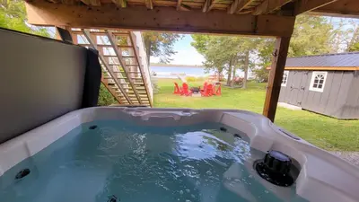 a jacuzzi tub with a view of a backyard at Impressive Modern Waterfront Home on Georgian Bay in Port McNicoll