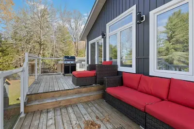 a house with a red couch on a deck at Impressive Modern Waterfront Home on Georgian Bay in Port McNicoll