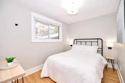 a white bedroom with a bed and a window at The Newark House in Niagara on the Lake