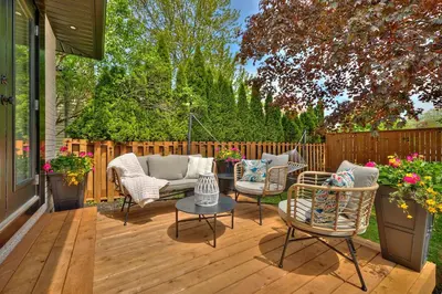 a patio with chairs and a couch on a wooden deck at The Newark House in Niagara on the Lake