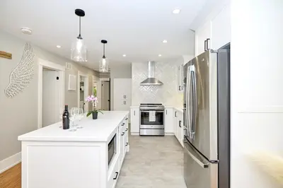 a kitchen with white cabinets and a refrigerator at The Newark House in Niagara on the Lake